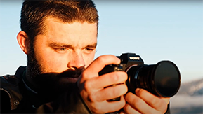 Foto: Henrik hält eine Kamera auf Gesichtshöhe und blickt auf das Display